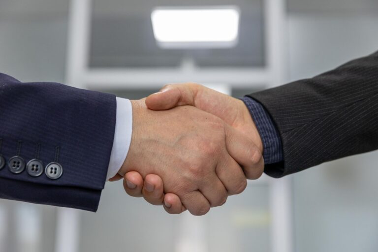 Business handshake representing choosing a white-label partner over in-house hiring