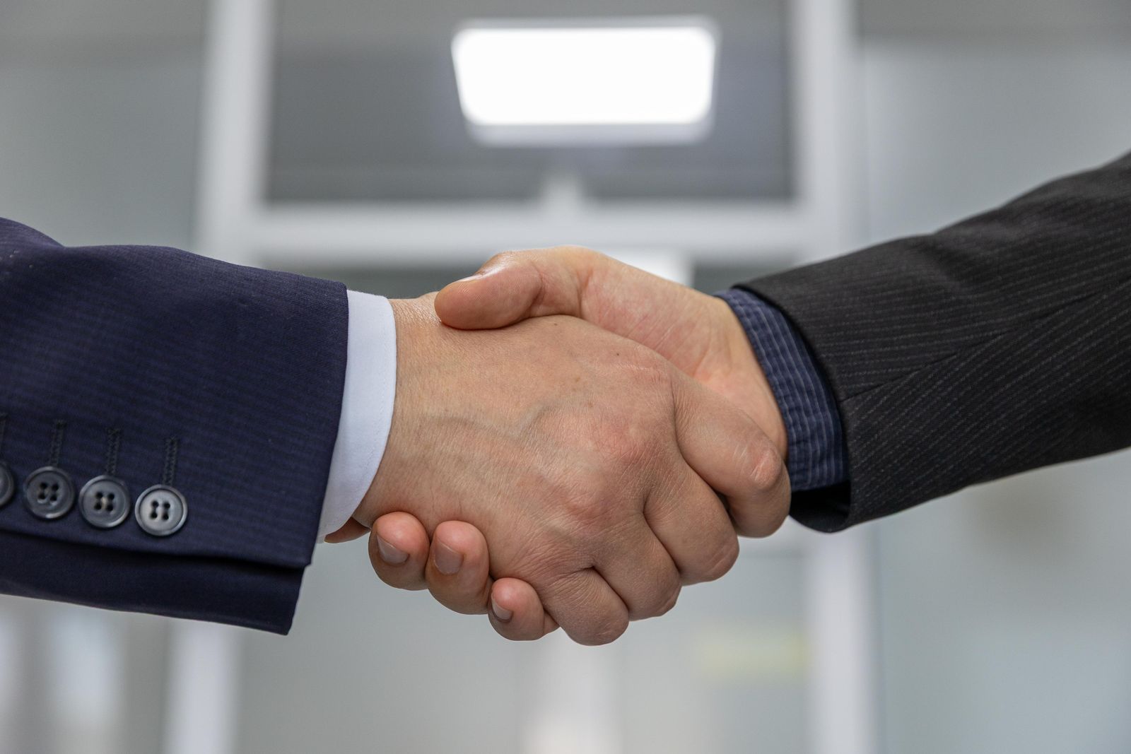 Business handshake representing choosing a white-label partner over in-house hiring