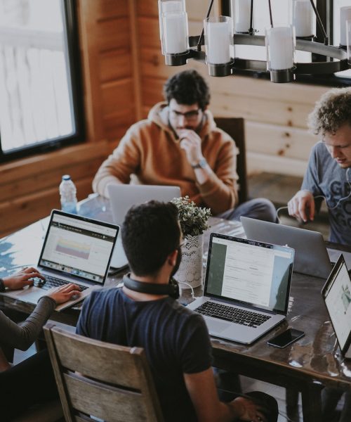 men sitting in front of their laptop computer